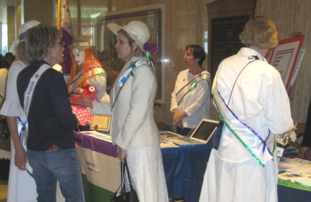 LWV table at the legislature, with women dressed as suffragettes